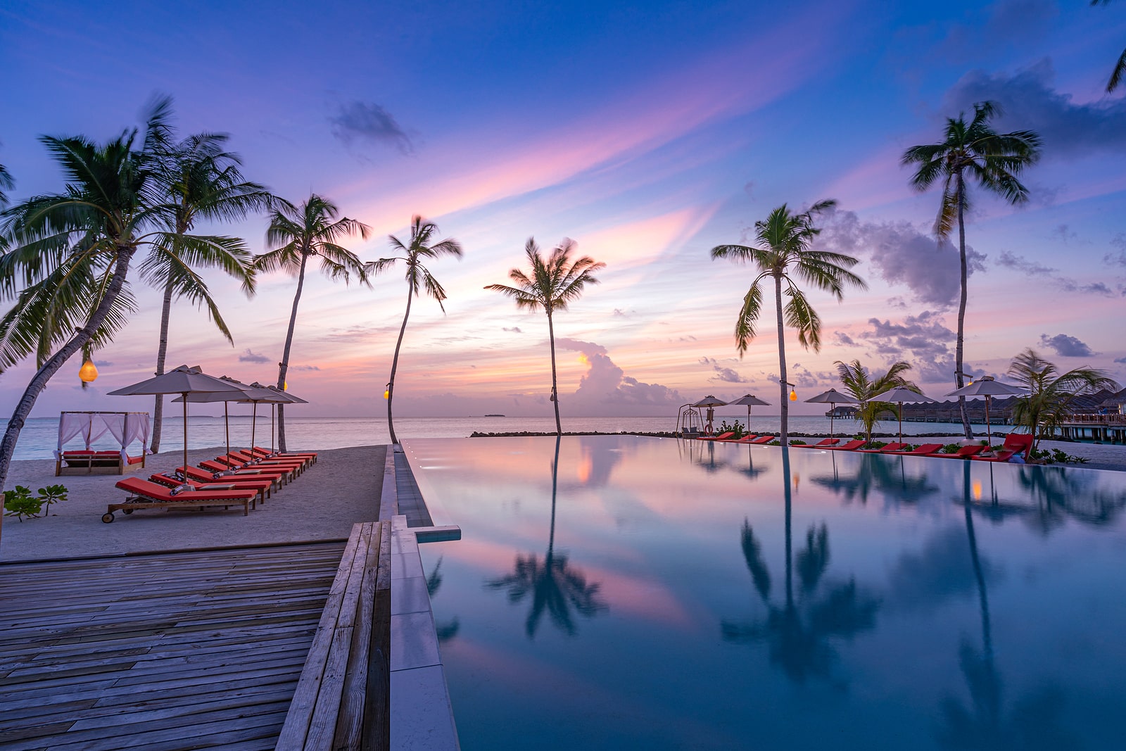 Luxury Sunset Over Infinity Pool In A Summer Beachfront Hotel Re